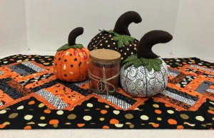 table runner, pumpkins, and candle