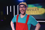 Image of a man wearing a hat and glasses who is smiling.
